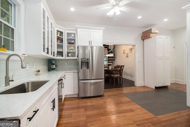 1292 Eubanks Ave, East Point, GA 30344 - kitchen featuring appliances with stainless steel finishes, tasteful backsplash, ceiling fan, wood finished floors, and white cabinetry