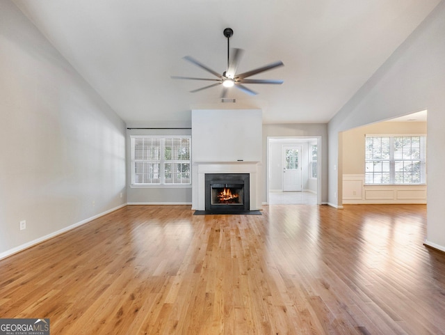 6439 Mossy Boulder Dr, Flowery Branch, GA 30542 - unfurnished living room with ceiling fan, lofted ceiling, light wood-type flooring, and a fireplace with flush hearth