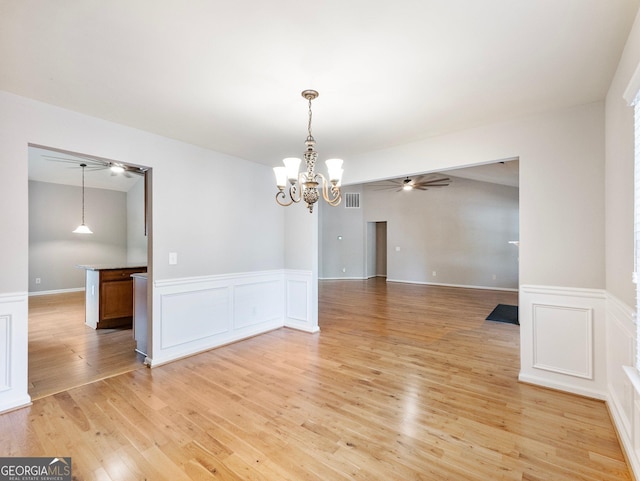 6439 Mossy Boulder Dr, Flowery Branch, GA 30542 - unfurnished room featuring a chandelier, wainscoting, light wood-style flooring, a decorative wall, and ceiling fan