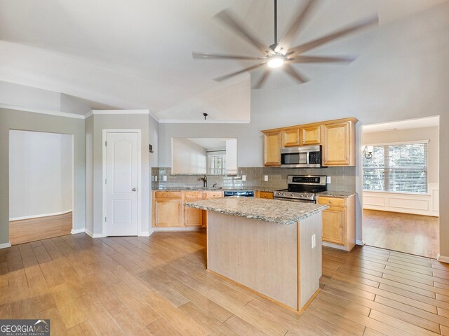 6439 Mossy Boulder Dr, Flowery Branch, GA 30542 - kitchen featuring stainless steel appliances, light brown cabinetry, a center island, a ceiling fan, and lofted ceiling