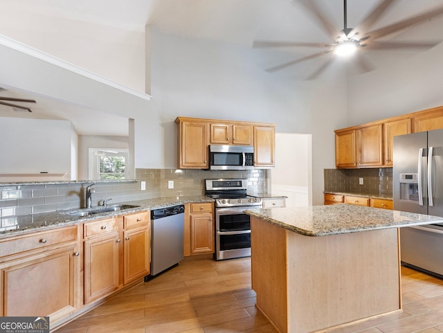 6439 Mossy Boulder Dr, Flowery Branch, GA 30542 - kitchen with stainless steel appliances, a ceiling fan, a high ceiling, tasteful backsplash, and light stone counters