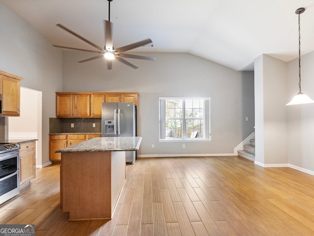 6439 Mossy Boulder Dr, Flowery Branch, GA 30542 - kitchen featuring appliances with stainless steel finishes, a kitchen island, a ceiling fan, light wood-type flooring, and light stone counters
