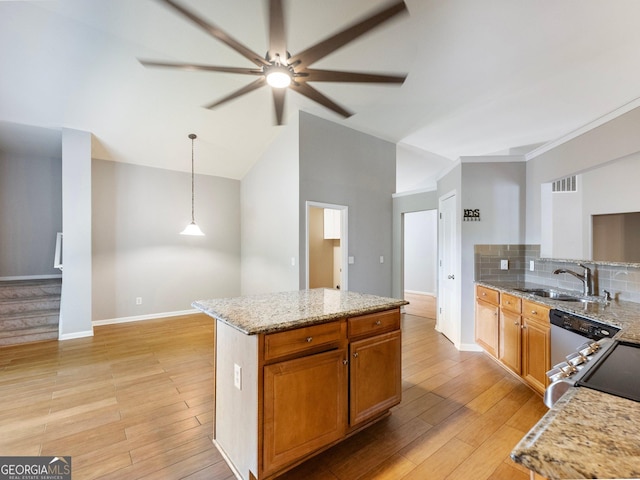 6439 Mossy Boulder Dr, Flowery Branch, GA 30542 - kitchen with a ceiling fan, light wood-type flooring, light stone countertops, a center island, and vaulted ceiling