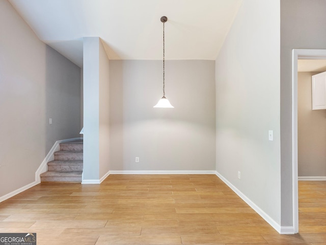 6439 Mossy Boulder Dr, Flowery Branch, GA 30542 - unfurnished dining area with light wood-style floors, stairs, and lofted ceiling