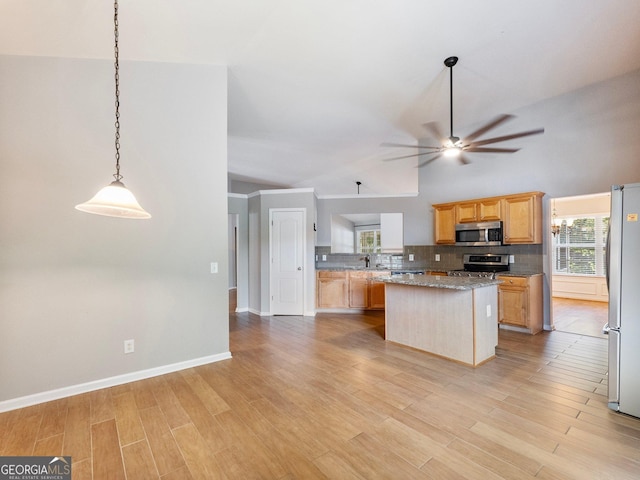 6439 Mossy Boulder Dr, Flowery Branch, GA 30542 - kitchen with stainless steel appliances, ceiling fan, tasteful backsplash, a kitchen island, and light wood-style flooring