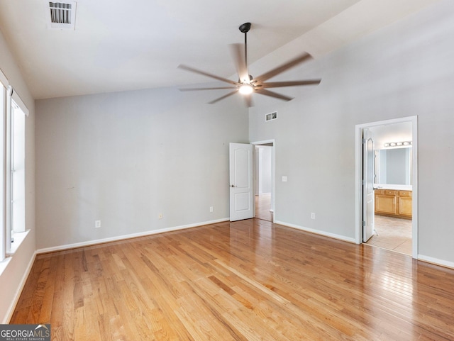6439 Mossy Boulder Dr, Flowery Branch, GA 30542 - unfurnished bedroom featuring light wood-type flooring, high vaulted ceiling, connected bathroom, and ceiling fan