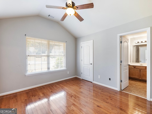 6439 Mossy Boulder Dr, Flowery Branch, GA 30542 - unfurnished bedroom featuring light wood-type flooring, lofted ceiling, connected bathroom, and ceiling fan