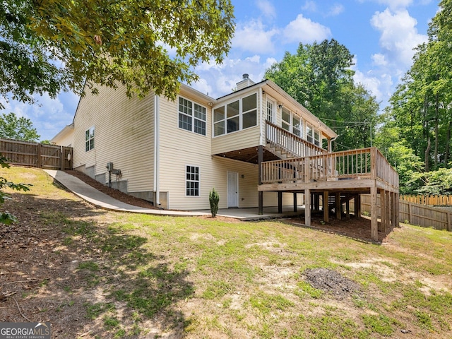 6439 Mossy Boulder Dr, Flowery Branch, GA 30542 - back of house featuring a sunroom, a deck, a chimney, stairs, and a patio