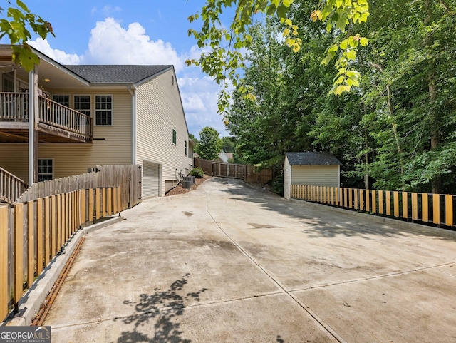 6439 Mossy Boulder Dr, Flowery Branch, GA 30542 - view of side of home featuring concrete driveway, a shed, and a fenced backyard