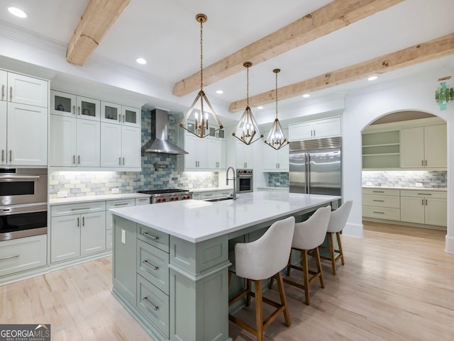 5832 Lula Bridge Ln, Braselton, GA 30517 - kitchen featuring wall chimney range hood, appliances with stainless steel finishes, backsplash, beamed ceiling, and a kitchen bar