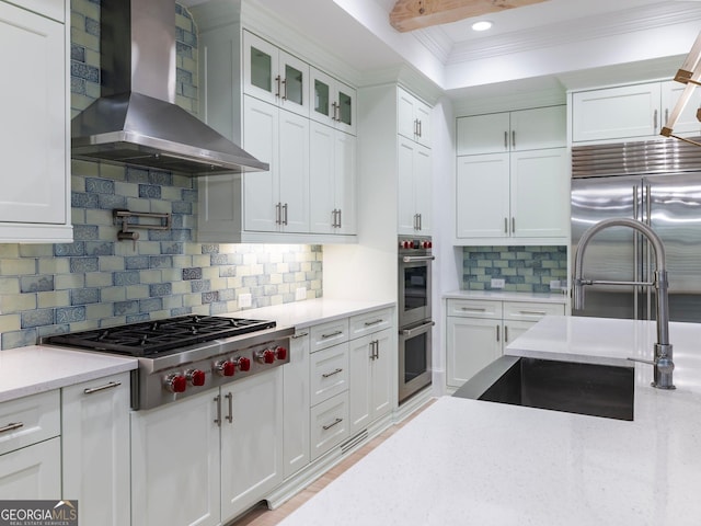 5832 Lula Bridge Ln, Braselton, GA 30517 - kitchen featuring wall chimney exhaust hood, appliances with stainless steel finishes, white cabinetry, crown molding, and tasteful backsplash