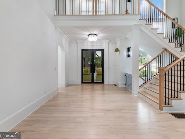 5832 Lula Bridge Ln, Braselton, GA 30517 - foyer featuring arched walkways, wood finished floors, stairway, a high ceiling, and french doors