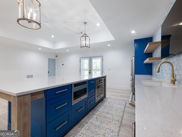 5832 Lula Bridge Ln, Braselton, GA 30517 - kitchen with open shelves, stainless steel appliances, a raised ceiling, blue cabinets, and crown molding