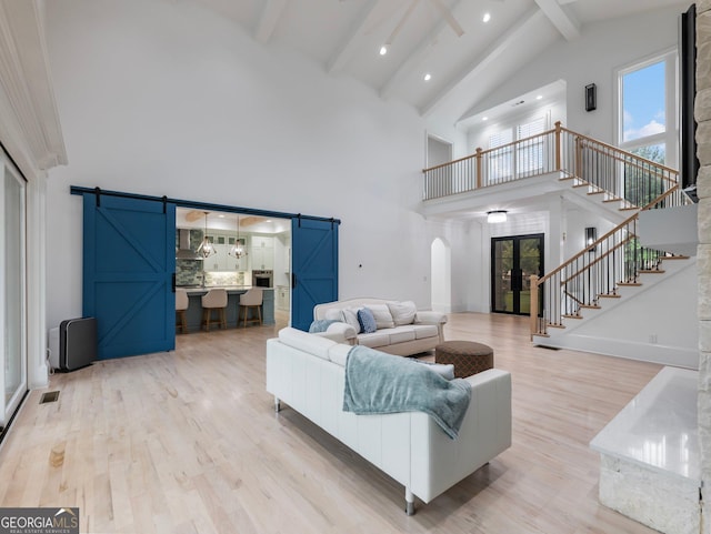 5832 Lula Bridge Ln, Braselton, GA 30517 - living room with a barn door, high vaulted ceiling, beam ceiling, arched walkways, and stairway