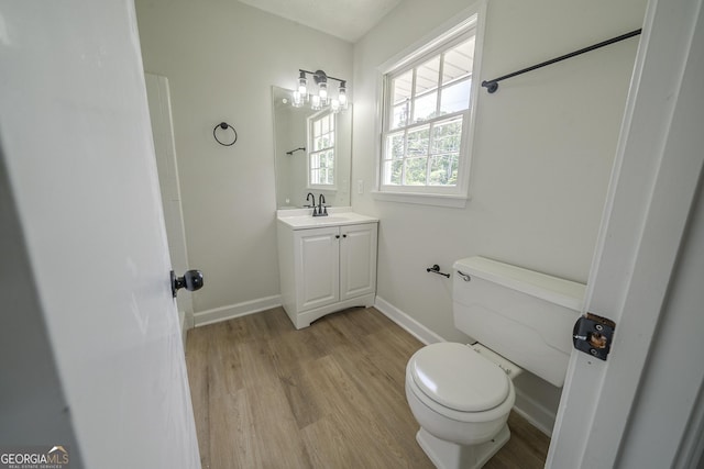 4732 Manly Ct, Stone Mountain, GA 30088 - half bathroom featuring toilet, wood finished floors, vanity, and baseboards