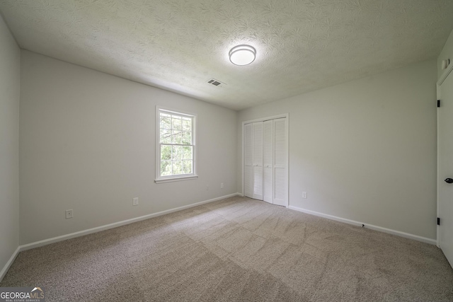 4732 Manly Ct, Stone Mountain, GA 30088 - unfurnished bedroom with a closet, baseboards, a textured ceiling, and light carpet