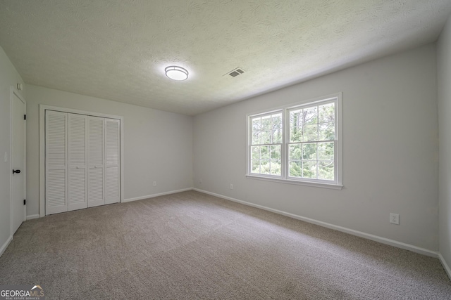 4732 Manly Ct, Stone Mountain, GA 30088 - unfurnished bedroom featuring carpet, baseboards, a closet, and a textured ceiling