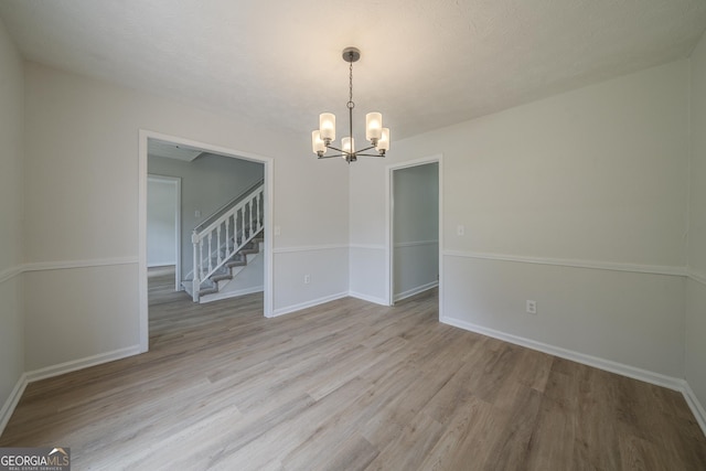 4732 Manly Ct, Stone Mountain, GA 30088 - unfurnished room with a chandelier, light wood-type flooring, baseboards, and stairs