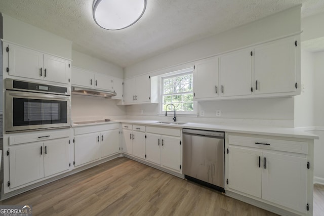 4732 Manly Ct, Stone Mountain, GA 30088 - kitchen featuring stainless steel appliances, light wood-style flooring, white cabinets, light countertops, and a sink