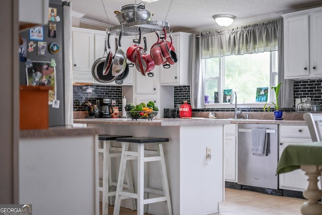 6162 Ayrin Brooke Ln, Blackshear, GA 31516 - kitchen with dishwasher, white cabinetry, tasteful backsplash, a kitchen bar, and crown molding