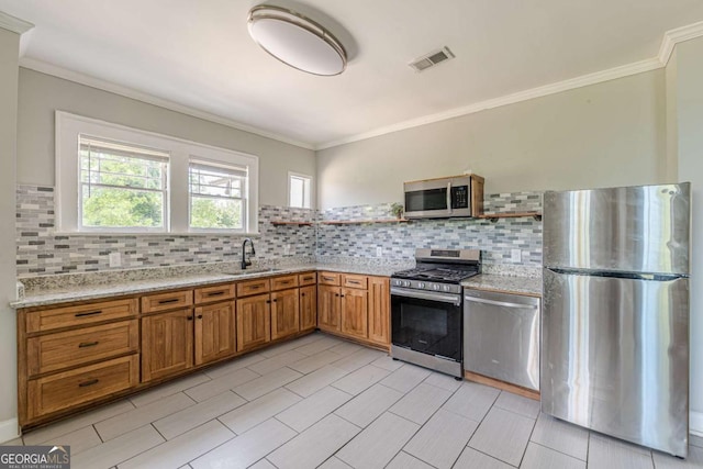 975 Dill Ave SW, Atlanta, GA 30310 - kitchen with stainless steel appliances, brown cabinets, tasteful backsplash, ornamental molding, and light stone countertops
