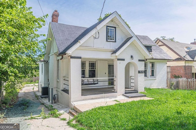 975 Dill Ave SW, Atlanta, GA 30310 - view of front of property featuring brick siding, a chimney, roof with shingles, and a porch