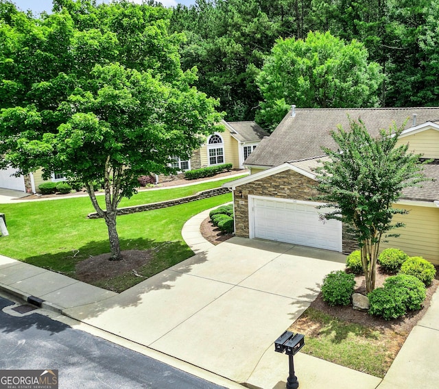 140 Rehobeth Way, Fayetteville, GA 30214 - obstructed view of property with stone siding, concrete driveway, a front lawn, an attached garage, and a shingled roof