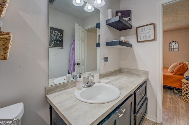 527 Malcom Rd, Covington, GA 30014 - bathroom with vanity, wood finished floors, toilet, and connected bathroom