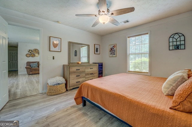 527 Malcom Rd, Covington, GA 30014 - bedroom featuring light wood finished floors, ceiling fan, and a textured ceiling