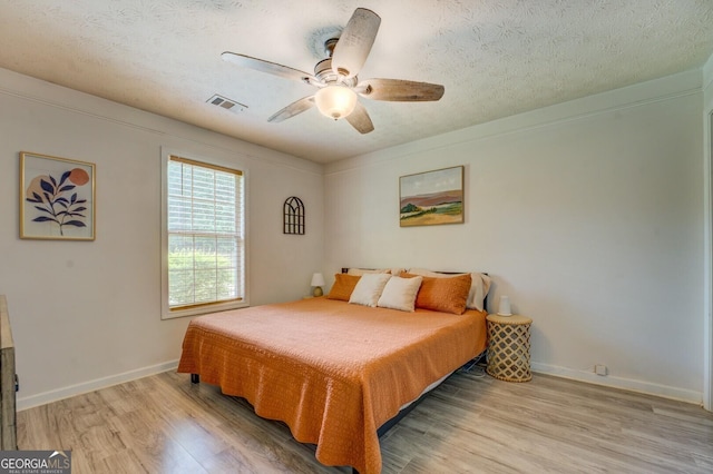 527 Malcom Rd, Covington, GA 30014 - bedroom featuring light wood-style floors, a textured ceiling, baseboards, and a ceiling fan