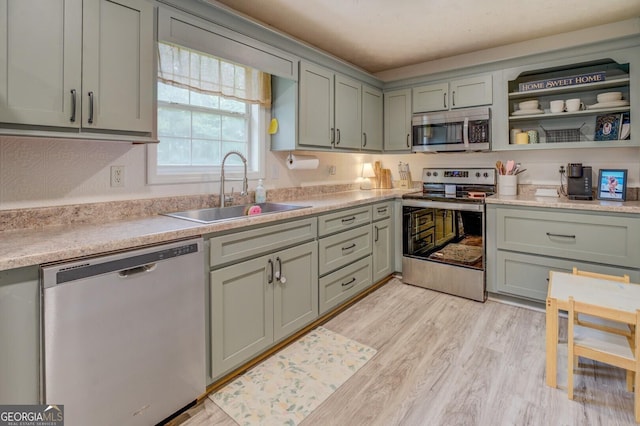 527 Malcom Rd, Covington, GA 30014 - kitchen featuring stainless steel appliances, a sink, light wood-style flooring, light countertops, and open shelves