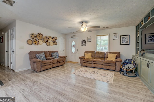 527 Malcom Rd, Covington, GA 30014 - living area with light wood-style flooring, a ceiling fan, a textured ceiling, and baseboards