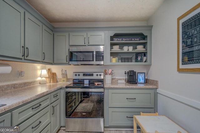527 Malcom Rd, Covington, GA 30014 - kitchen featuring appliances with stainless steel finishes, light countertops, gray cabinetry, and open shelves