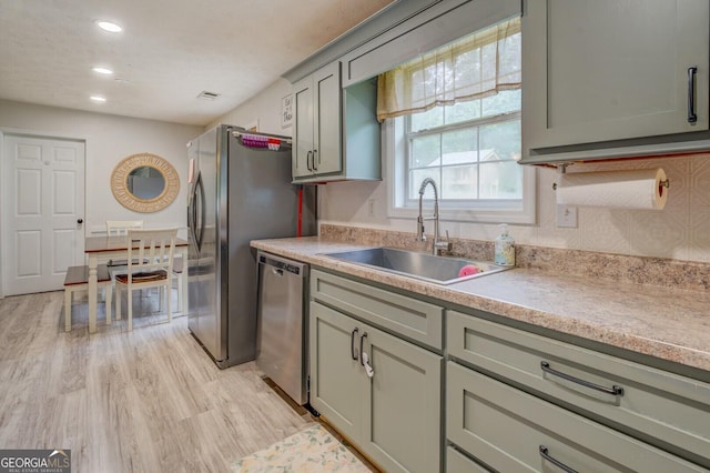 527 Malcom Rd, Covington, GA 30014 - kitchen with stainless steel dishwasher, a sink, light wood-style flooring, light countertops, and recessed lighting