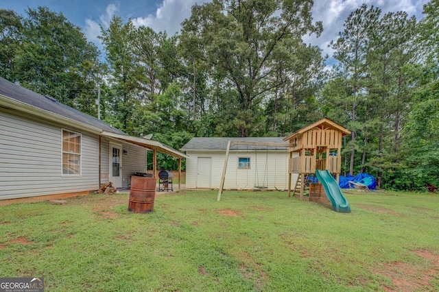 527 Malcom Rd, Covington, GA 30014 - view of green lawn with a playground and view of scattered trees