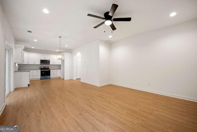 4095 Oriole Ln, Fairburn, GA 30213 - unfurnished living room with arched walkways, light wood-type flooring, recessed lighting, and a ceiling fan