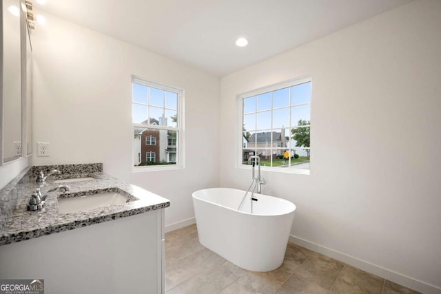 4095 Oriole Ln, Fairburn, GA 30213 - bathroom featuring double vanity, a freestanding tub, and recessed lighting