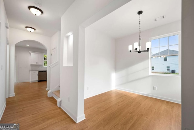 4095 Oriole Ln, Fairburn, GA 30213 - corridor featuring light wood finished floors, a chandelier, arched walkways, and plenty of natural light