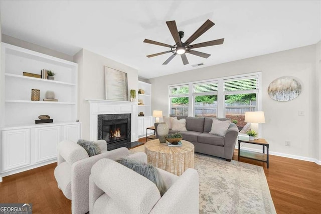 3607 Archgate Ct, Alpharetta, GA 30004 - living room featuring ceiling fan, a fireplace, wood finished floors, and built in features
