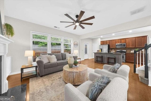 3607 Archgate Ct, Alpharetta, GA 30004 - living room featuring a ceiling fan, light wood-style flooring, recessed lighting, stairs, and a fireplace
