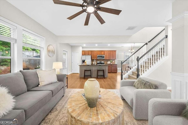 3607 Archgate Ct, Alpharetta, GA 30004 - living room featuring light wood-type flooring, stairs, a ceiling fan, recessed lighting, and a chandelier