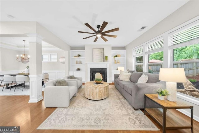 3607 Archgate Ct, Alpharetta, GA 30004 - living area featuring wood finished floors, a chandelier, a ceiling fan, a high end fireplace, and built in shelves