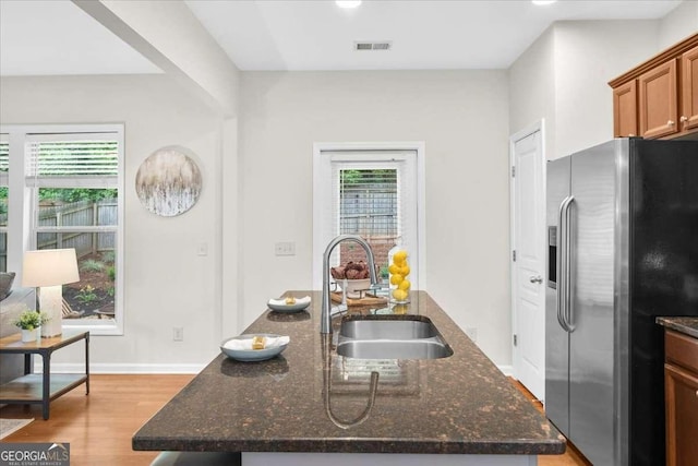 3607 Archgate Ct, Alpharetta, GA 30004 - kitchen with stainless steel fridge with ice dispenser, light wood finished floors, dark stone countertops, and brown cabinetry