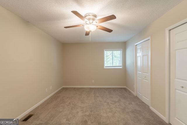4669 Birch Ridge Trl, Stone Mountain, GA 30083 - unfurnished bedroom with light colored carpet, a textured ceiling, a closet, and ceiling fan