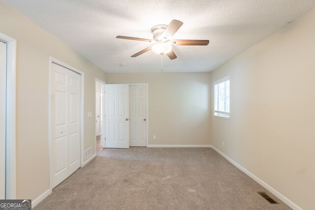 4669 Birch Ridge Trl, Stone Mountain, GA 30083 - unfurnished bedroom with carpet, a textured ceiling, and a ceiling fan