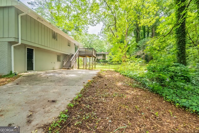 4669 Birch Ridge Trl, Stone Mountain, GA 30083 - view of yard with stairway, a deck, concrete driveway, and a patio