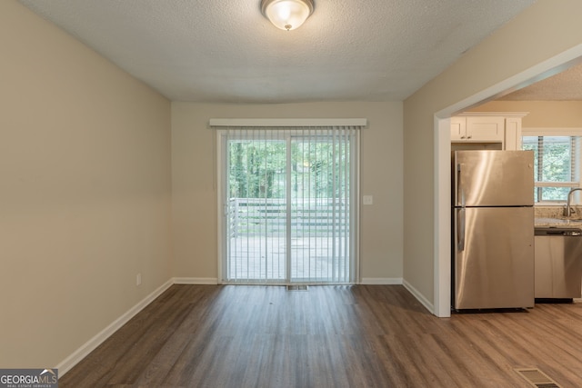 4669 Birch Ridge Trl, Stone Mountain, GA 30083 - kitchen featuring appliances with stainless steel finishes, wood finished floors, white cabinets, and a textured ceiling