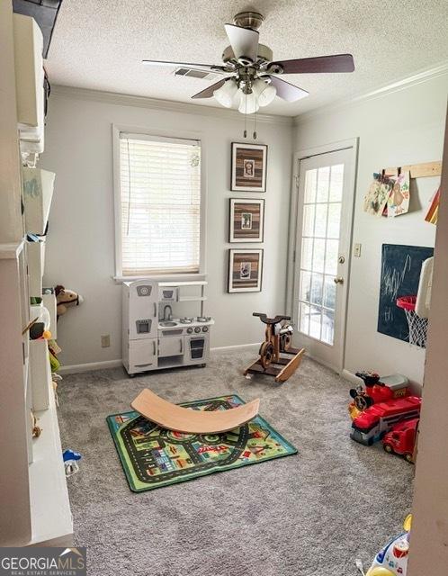 507 S College St, Metter, GA 30439 - playroom featuring crown molding, a textured ceiling, carpet, and a ceiling fan