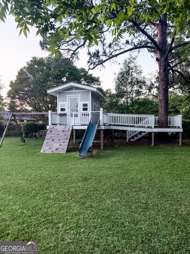 507 S College St, Metter, GA 30439 - rear view of property featuring board and batten siding, a yard, a playground, and a deck
