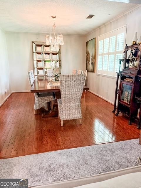 507 S College St, Metter, GA 30439 - dining area with wood-type flooring, a chandelier, crown molding, and baseboards